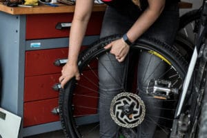Reifen am E-Bike wechseln - neuer Reifen mit Reifenheber aufziehen.