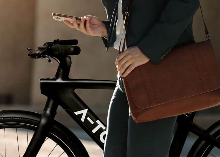 Businessman looking at his mobile phone while walking on street to office. Busy office going man commuting to office carrying his office bag and using mobile phone.; Shutterstock ID 1136901923; purchase_order: Consumer Goods; job: A-TO Smartbike; client: KSR; other: A-TO Katalog